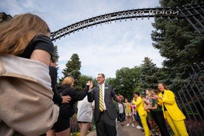 NDSU 总统 David Cook greets students at the university gates